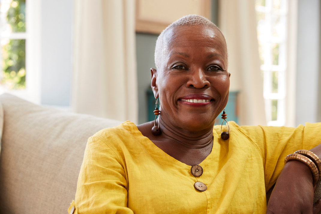 Smiling Senior Woman Sitting on Sofa at Home